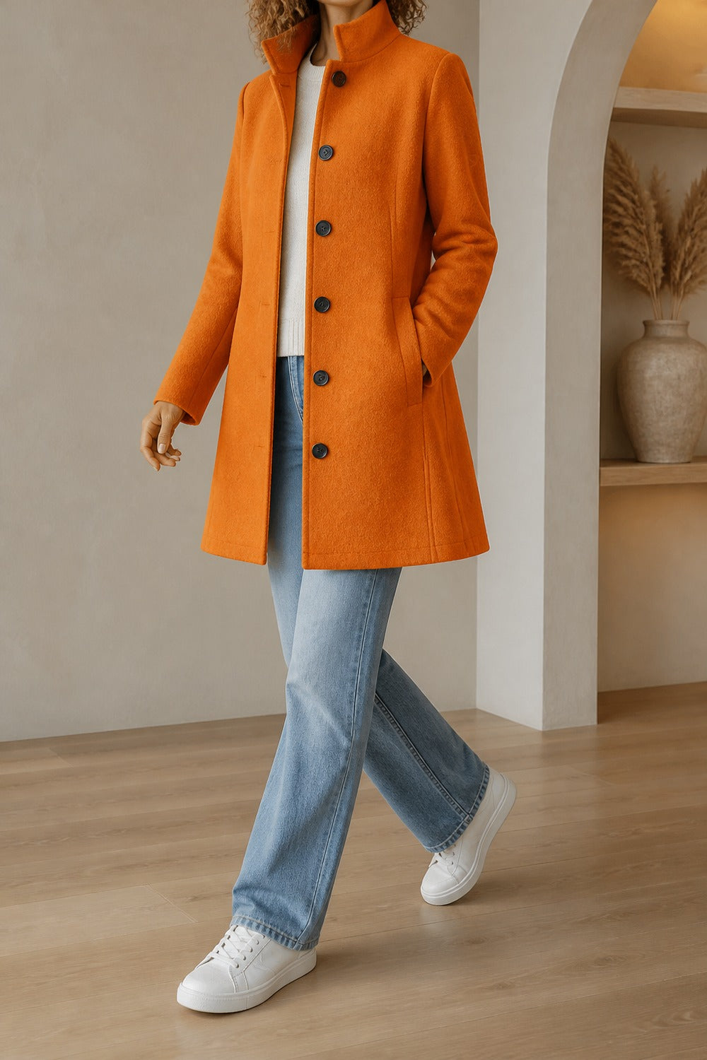 halflange mantel met opstaande kraag in oranje, zijaanzicht, al wandelend